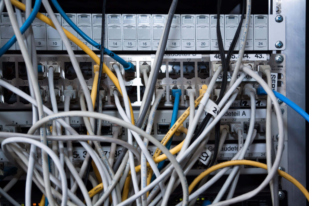 Close-up of tangled colorful Ethernet cables connected to network switches in data center infrastructure Wallpaper