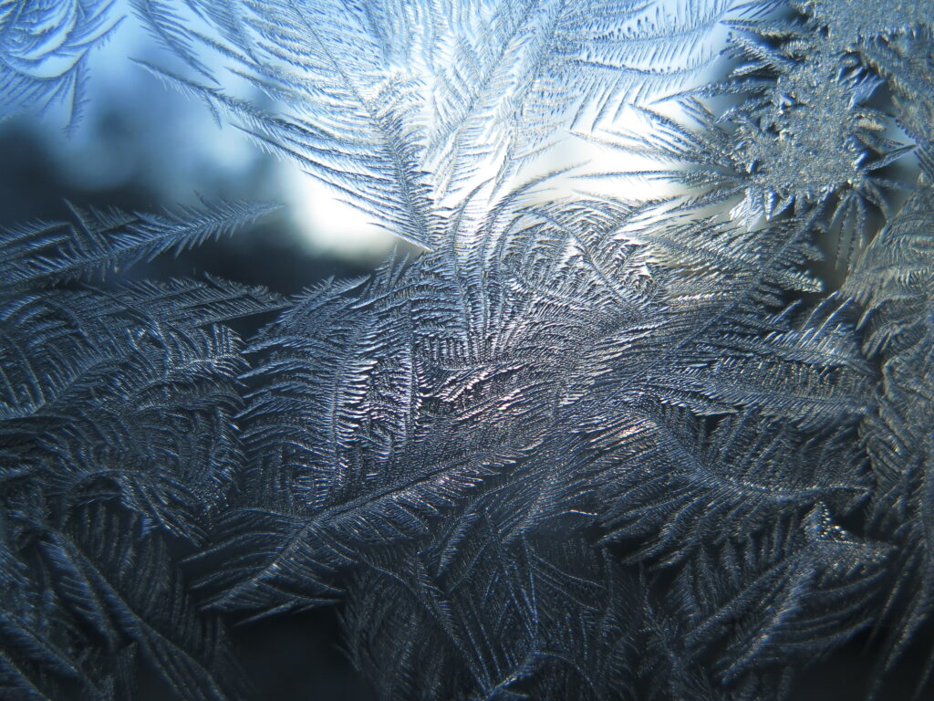 Intricate Frost Patterns on Glass: Delicate Icy Wallpaper Background