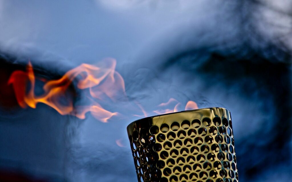 Intricate Metallic Torch Wallpaper with Vibrant Flame Background