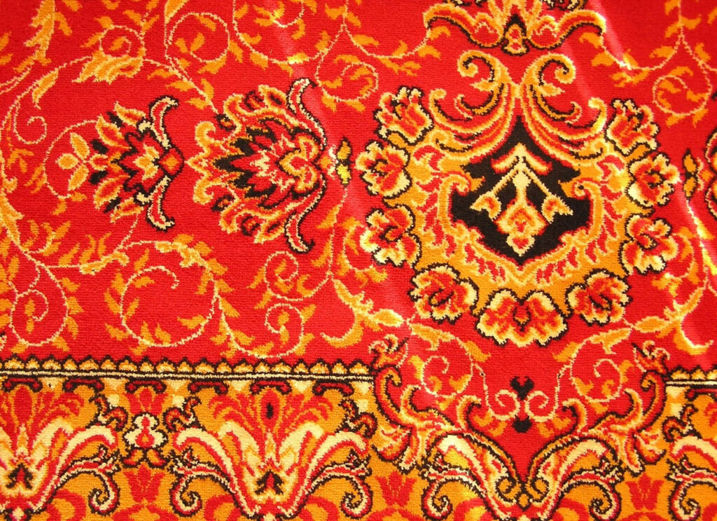 Close-Up of Rich Red and Gold Carpet: Intricate Patterns & Texture Wallpaper