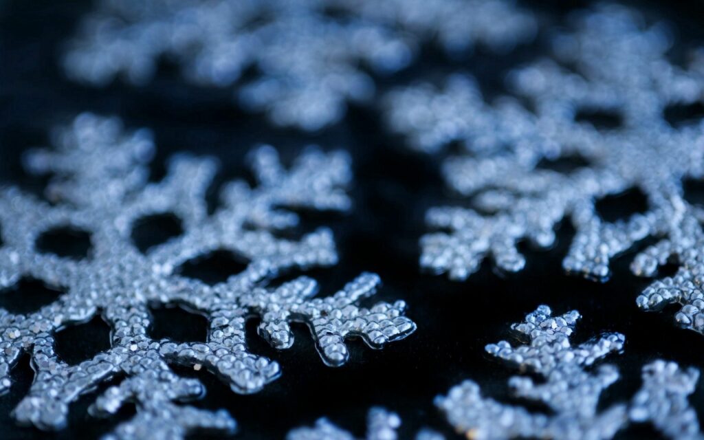 Festive Winter Wallpaper: Intricate Snowflakes on Dark Background