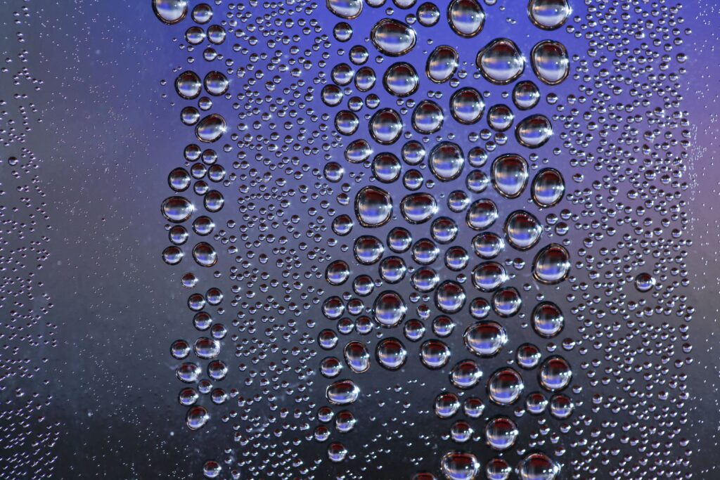 Intricate Water Droplets Wallpaper on Blurred Purple Background