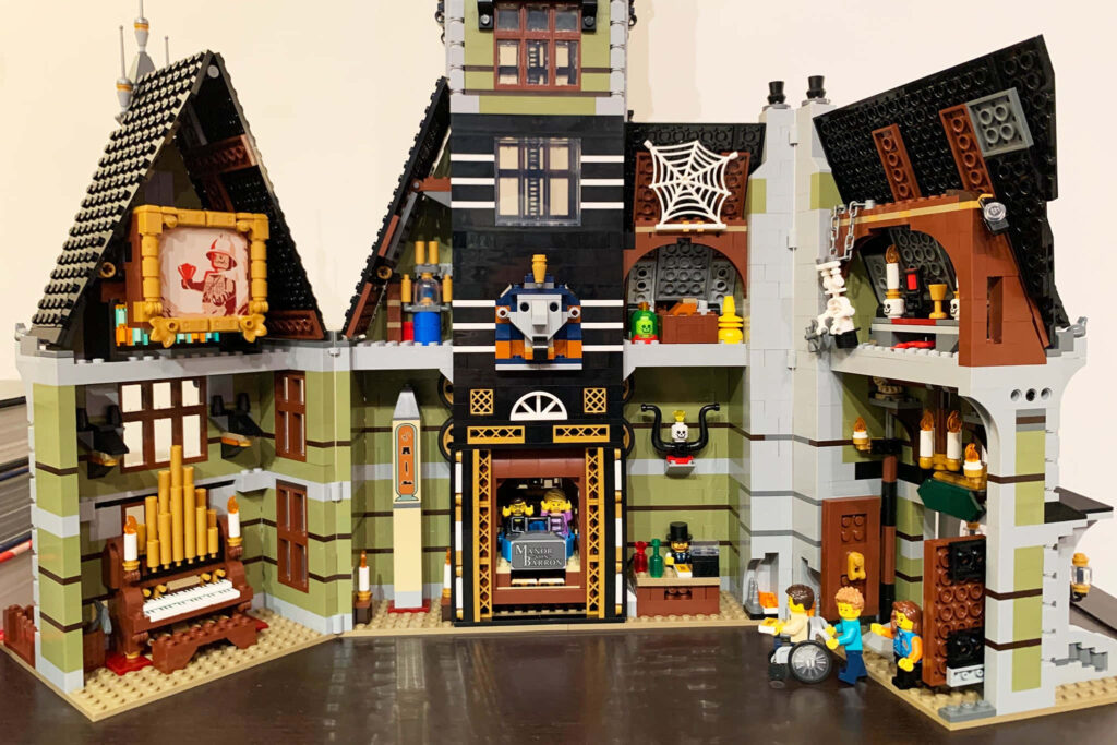 Intricately built Lego haunted house wallpaper with detailed rooms spooky decorations and mini-figures