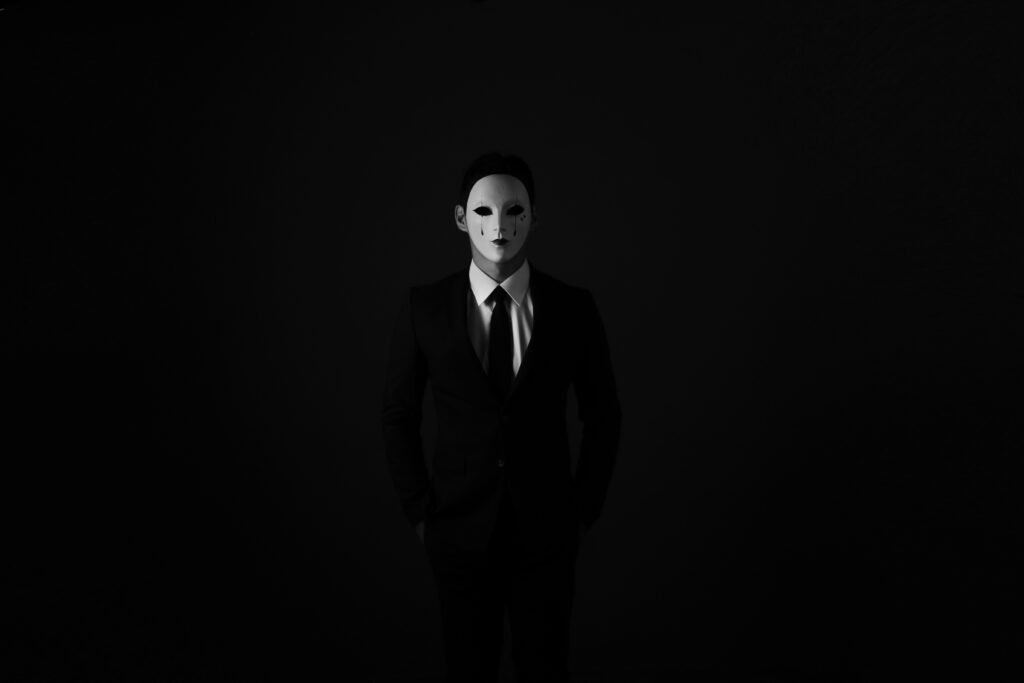 Intriguing Black and White Wallpaper: Mysterious Figure in Mask