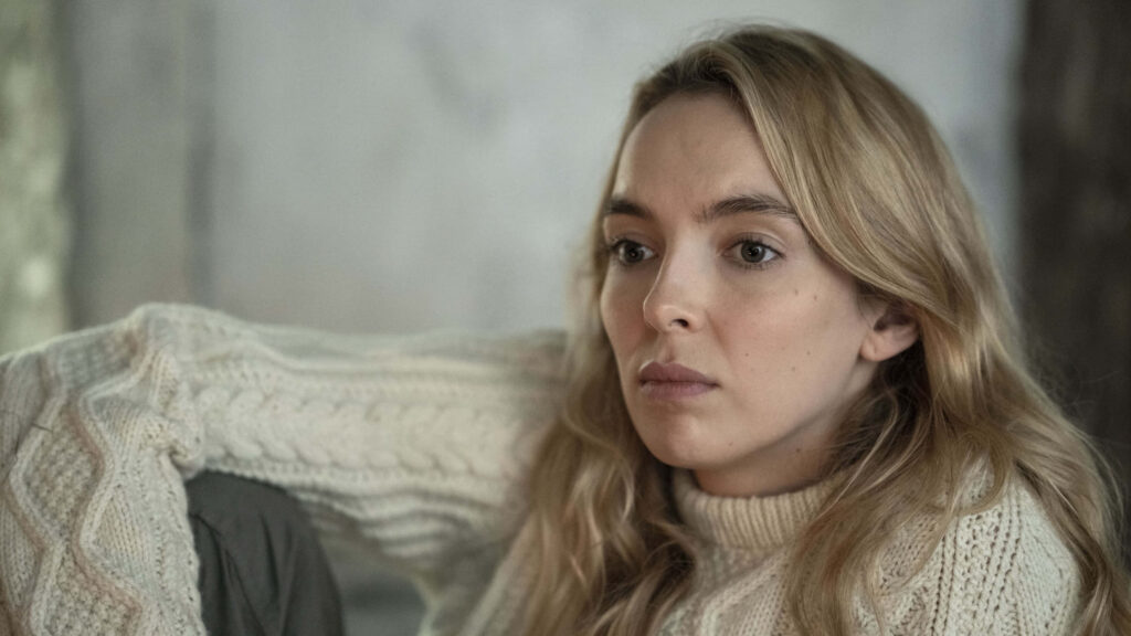 Introspective Killing Eve Character Wallpaper with Neutral Background