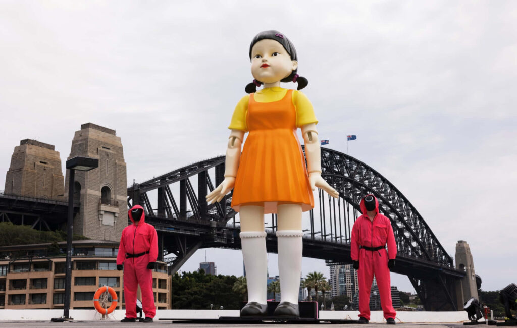 Bridge of Contrasting Creativity: Young-hee Doll and Squid Game's Red Guards Intersecting with Inventiveness Wallpaper