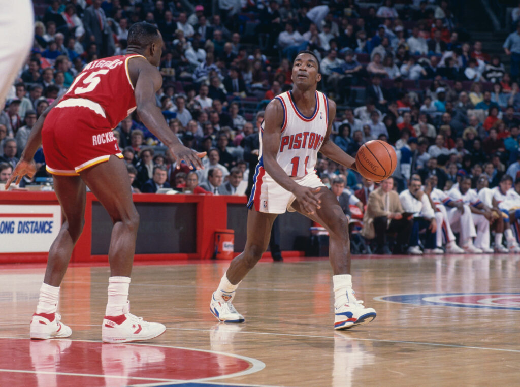 Isiah Thomas dribbling past Houston Rockets defender in intense 1990 NBA game action Wallpaper