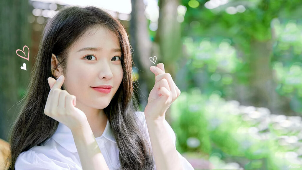 IU's Adorable Korean Heart Sign Pose: A Stunning Wallpaper of the K-Pop Singer Against a Dreamy Background