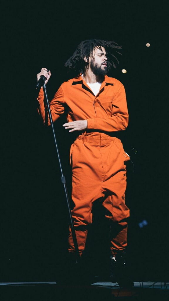 J Cole's Vibrant Orange Jumpsuit: Hip Hop Fashion Statement in HD Phone Wallpaper