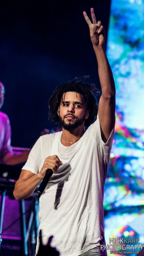 J Cole's Hip-Hop Serenade: Capturing the Rapper's Soulful Gesture in an Electrifying Performance Wallpaper