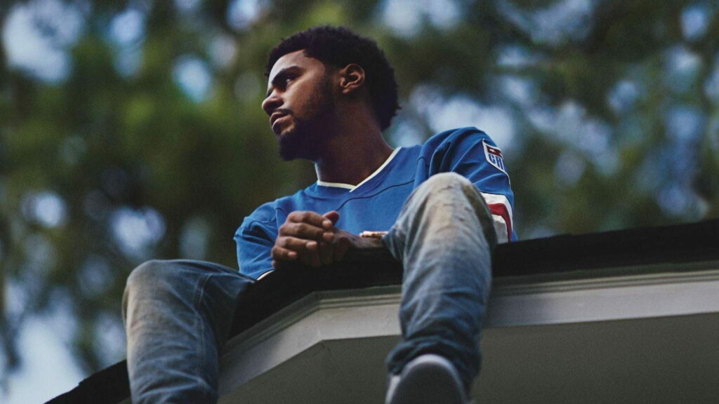 J Cole: The Melodic Mastermind Defying Gravity in a Stunning Rooftop Portrait Wallpaper