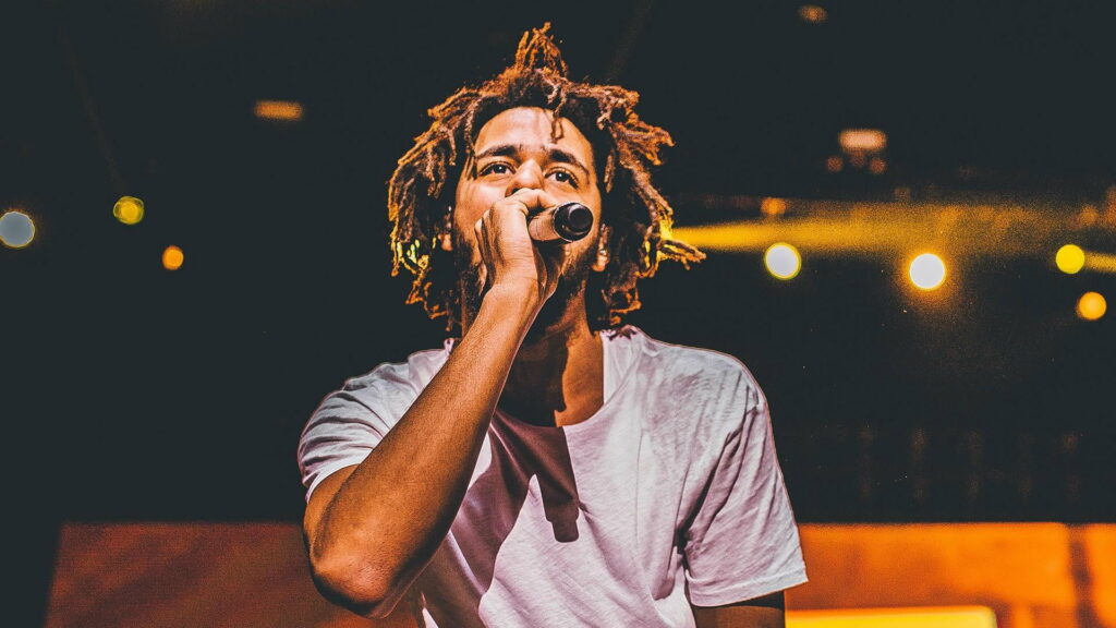 J Cole's Effortless Style Shines Under Vibrant Yellow Lights - HD Wallpaper