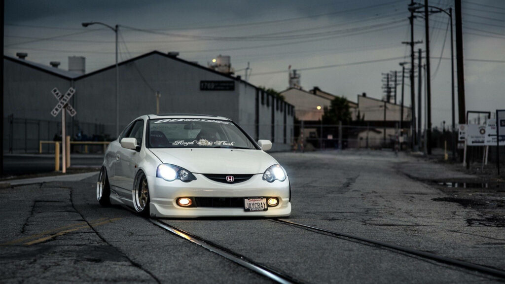 JDM Beauty in Motion: A Serene White Honda Civic Glides by Industrial Railways against Dusk-Hued Warehouses Wallpaper