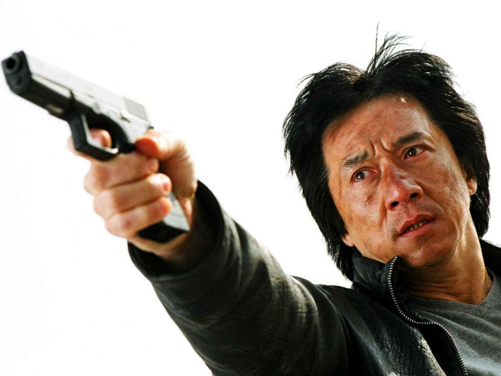 Jackie Chan intense pose aiming gun tough determined character dramatic wallpaper background