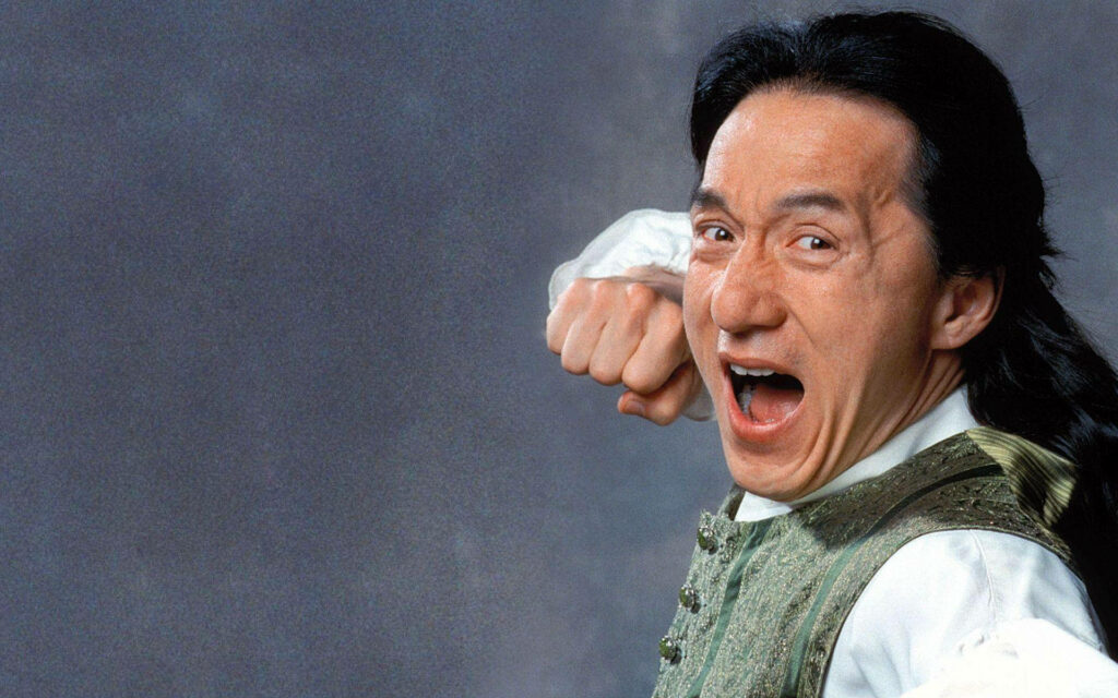 Jackie Chan mid-yell with raised fist dynamic action wallpaper background energetic pose