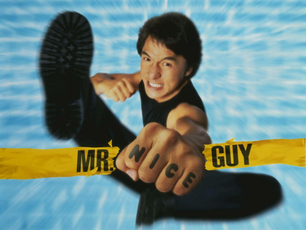 Young Jackie Chan action pose fist forward Mr Nice Guy wallpaper energetic charismatic background