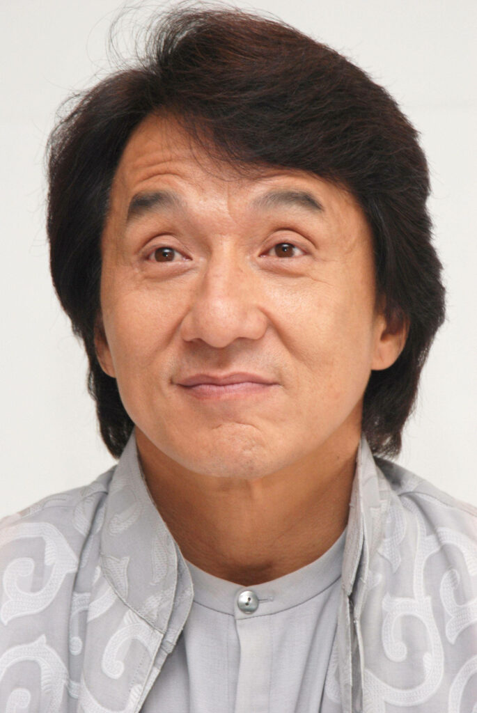 Close-up of Jackie Chan surprised expression detailed face soft neutral background wallpaper