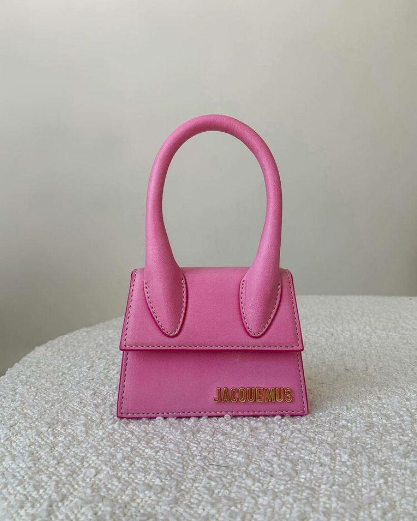 Stylish Jacquemus pink leather bag on minimalist background showcasing modern vibrant design Wallpaper