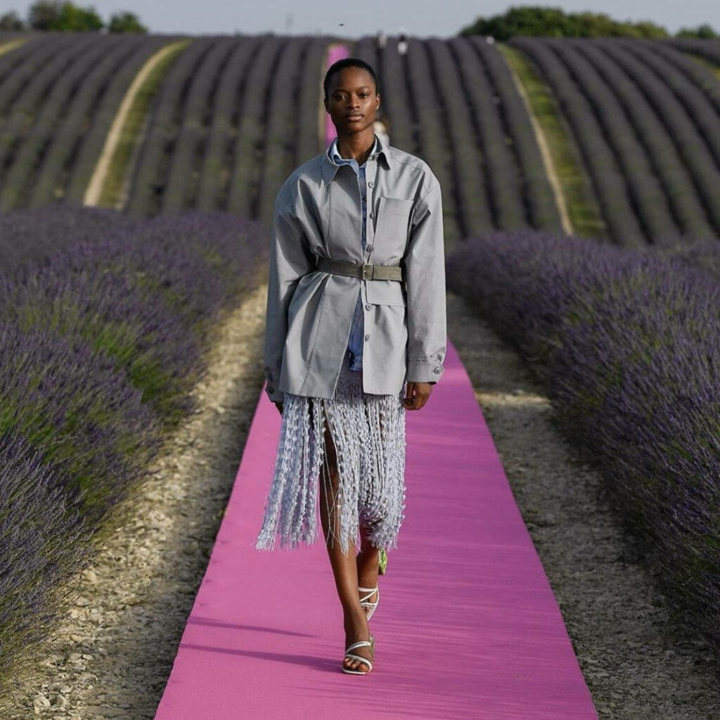 Model on pink runway at Jacquemus SS fashion show in lavender fields wearing belted jacket and skirt Wallpaper