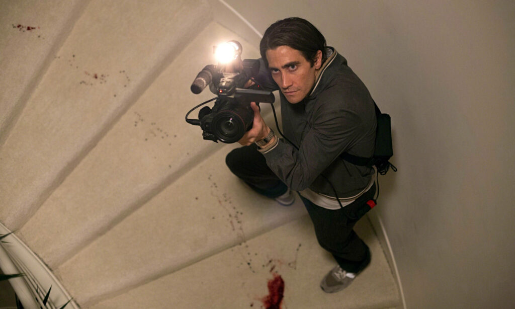 Jake Gyllenhaal filming suspenseful scene on blood-stained staircase intense cinematic moment Wallpaper