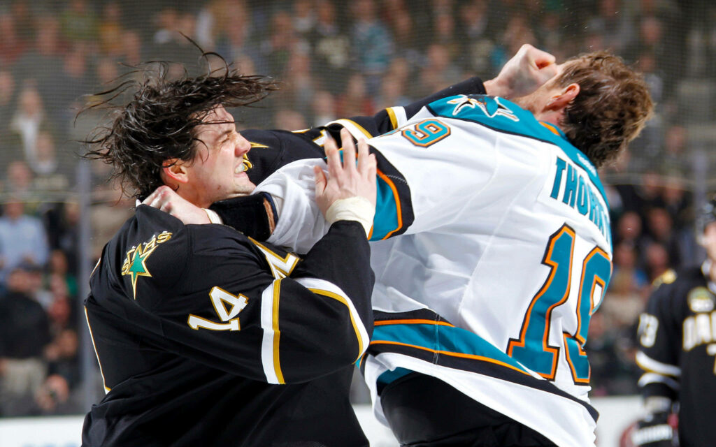 Jamie Benn and Joe Thornton fighting on ice intense Dallas Stars hockey action wallpaper background