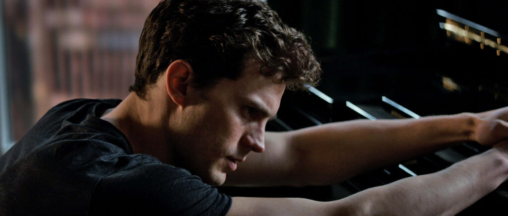 Jamie Dornan confident intense pose leaning forward charismatic personality wallpaper background