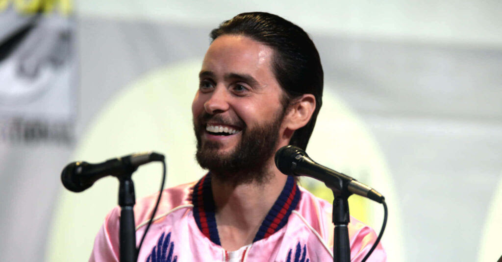 Jared Leto's Charismatic Smile in Stylish Pink Jacket Wallpaper