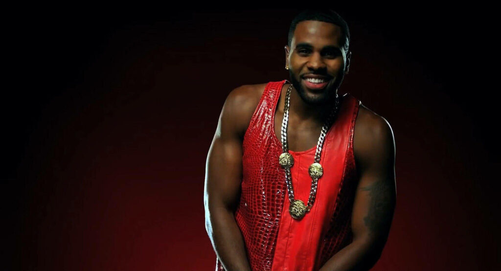 Jason Derulo in vibrant red outfit confidently posing dark background music video wallpaper