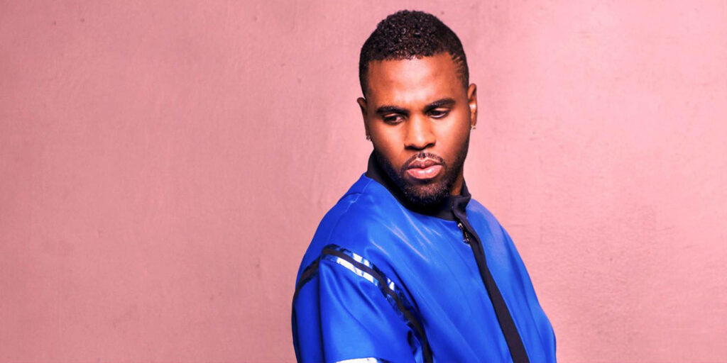 Jason Derulo in vibrant blue jacket thoughtful pose soft pink background stylish wallpaper