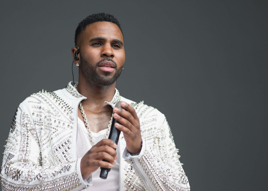 Jason Derulo confident stylish detailed embellished outfit holding microphone simple wallpaper