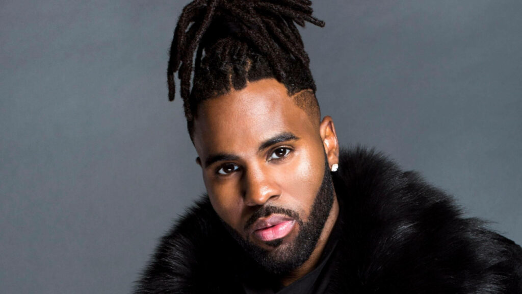 Jason Derulo portrait in fur-collared jacket with styled dreadlocks on gray background wallpaper