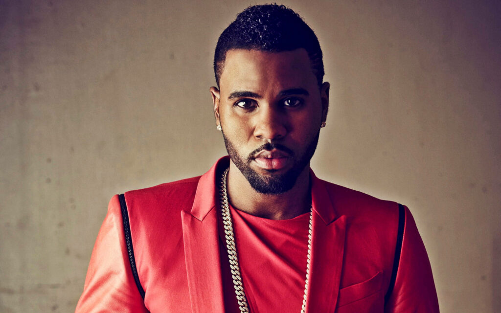 Jason Derulo confident in red suit with gold chain neutral background stylish wallpaper