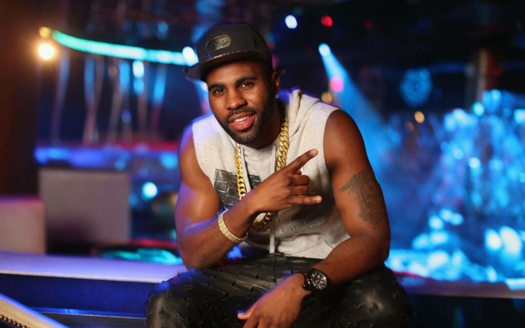 Jason Derulo confident pose in stylish studio with vibrant club lights modern wallpaper background