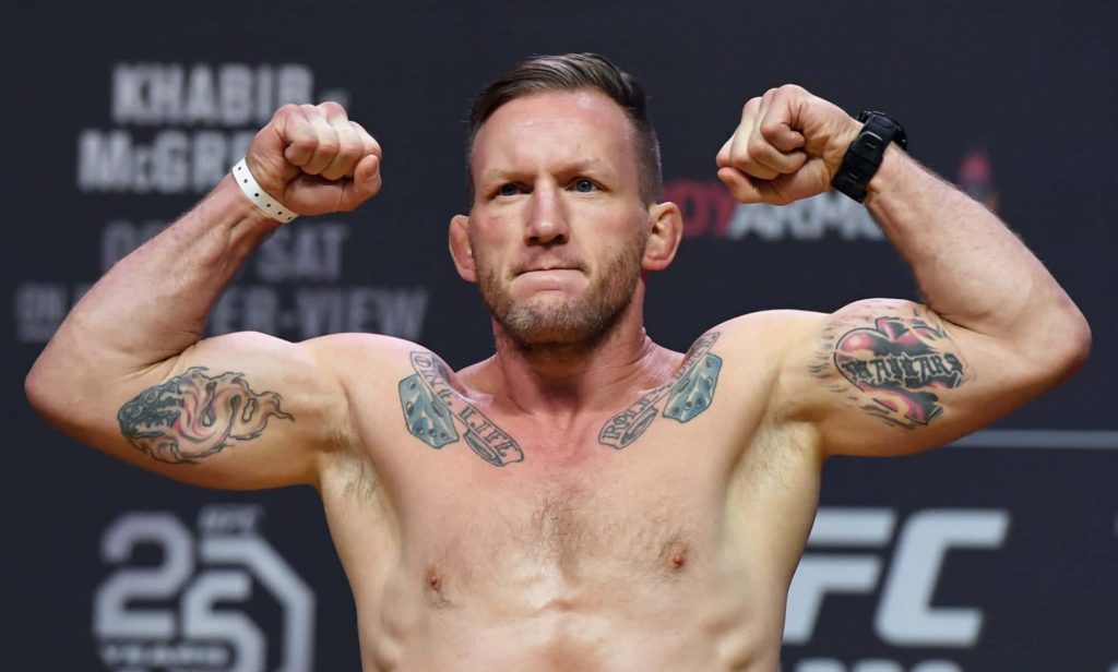 MMA fighter Jason Knight flexing with tattoos at UFC 25 anniversary weigh-in stage background Wallpaper