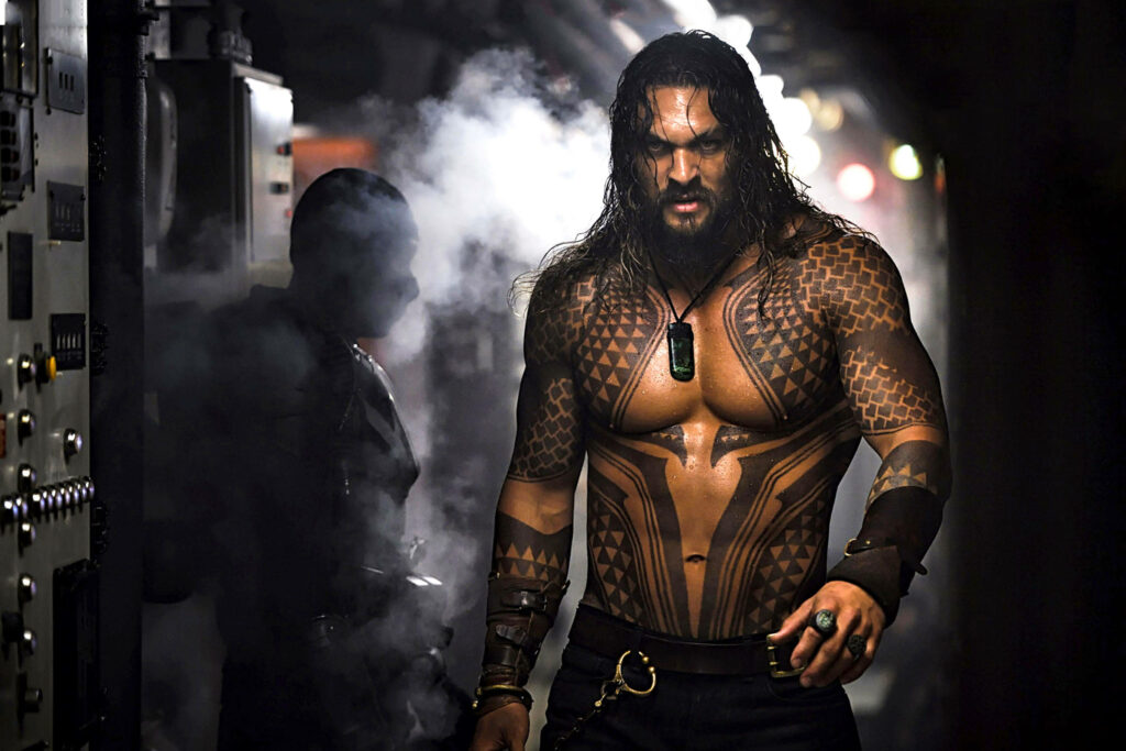 Jason Momoa as Aquaman stands on a ship with mist dramatic lighting showcasing tattoos Wallpaper