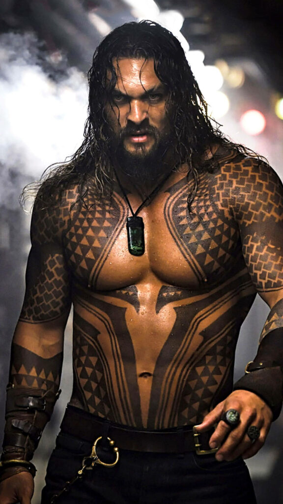 Jason Momoa as Aquaman with tattoos and intense expression dynamic superhero wallpaper background