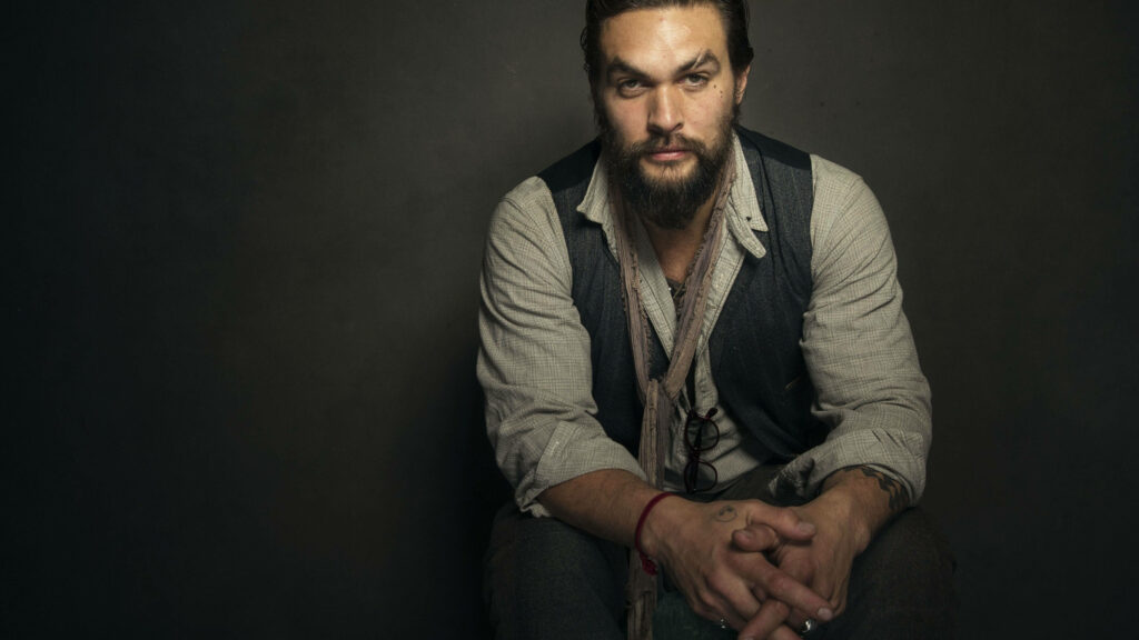 Jason Momoa intense studio portrait seated dark background charismatic powerful pose wallpaper