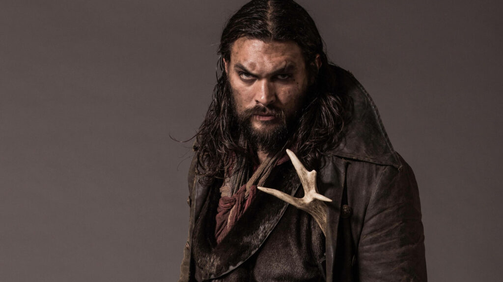 Jason Momoa as rugged fur trader in dark leather with intense expression on plain background Wallpaper