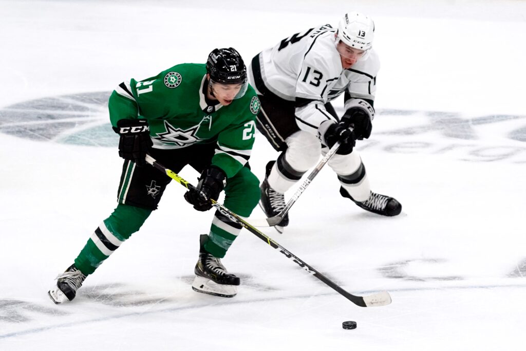 Jason Robertson Dallas Stars battles Gabriel Vilardi intense hockey game green white uniforms Wallpaper