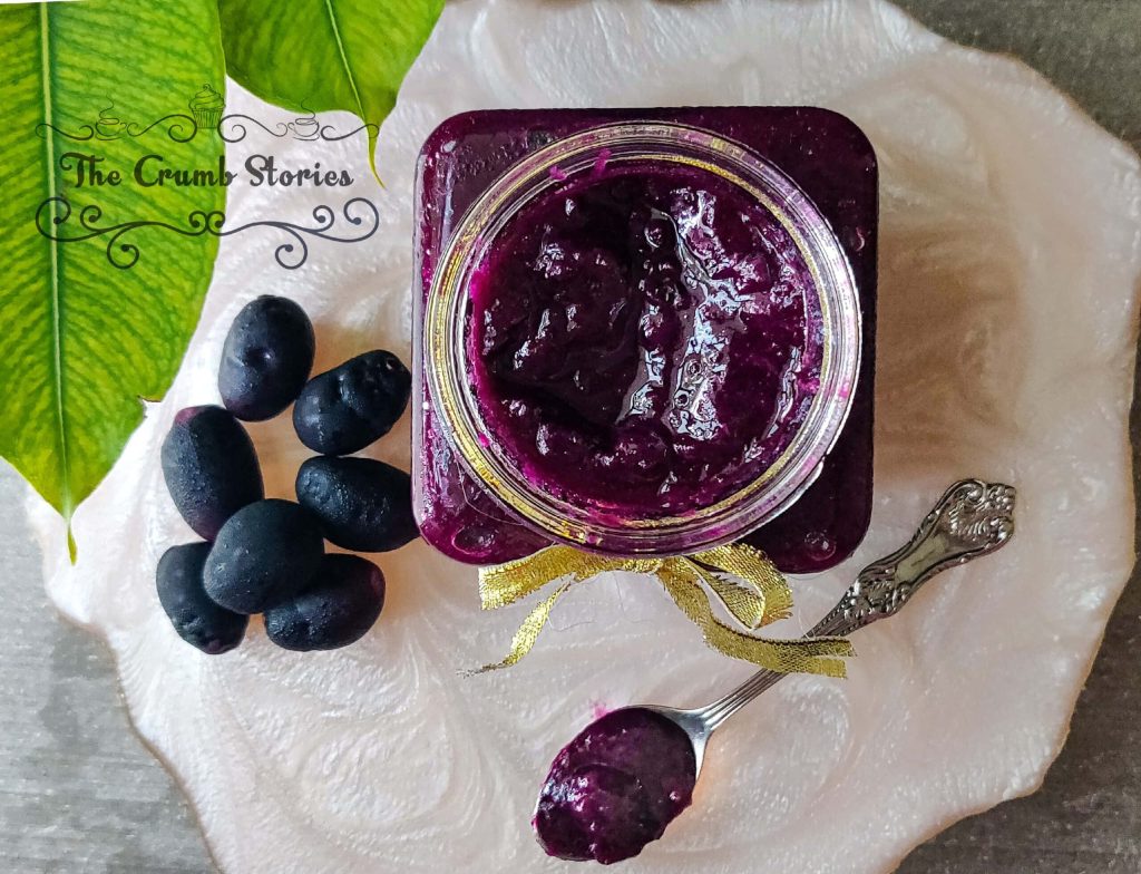 Top-down view of Java plum jam jar with fresh jamun and spoon on white plate bright light Wallpaper