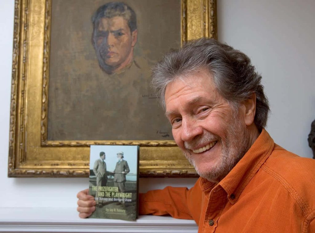Jay R Tunney holding book The Prizefighter and the Playwright with portrait of Gene Tunney background Wallpaper