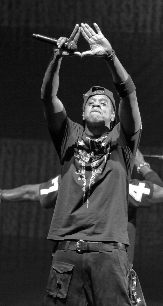 Jay-Z performing on stage black and white photo raising hands forming iconic symbol wallpaper