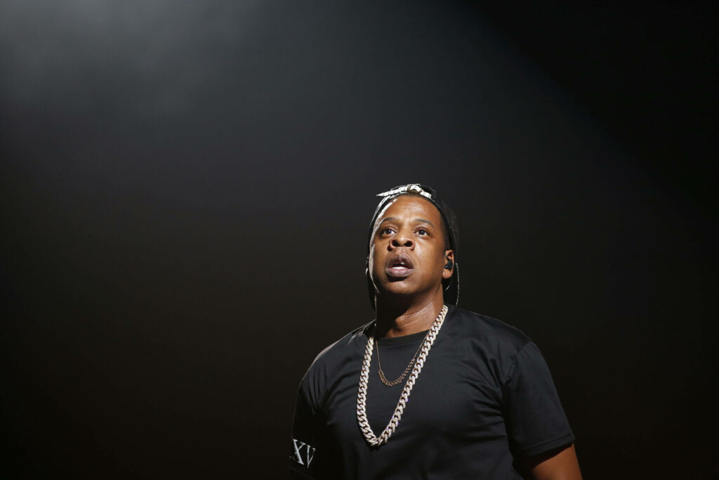 Jay-Z performing live on stage under dramatic lighting showcasing energy and presence wallpaper
