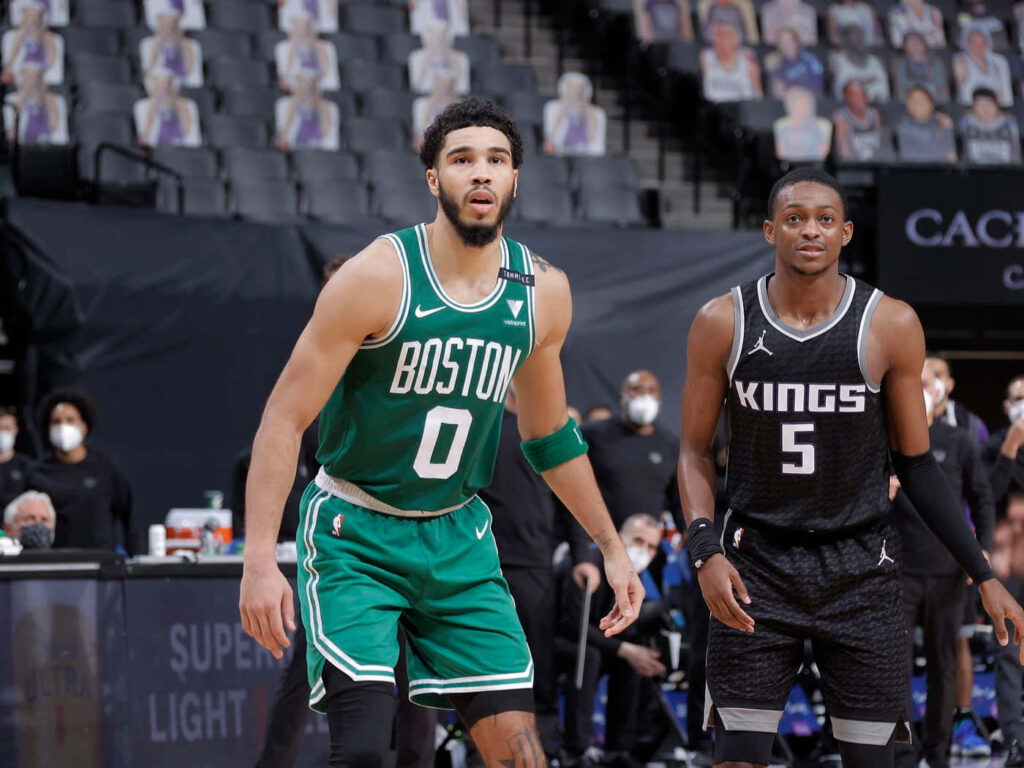 Jayson Tatum and DeAaron Fox intense basketball matchup Boston Celtics vs Sacramento Kings action Wallpaper