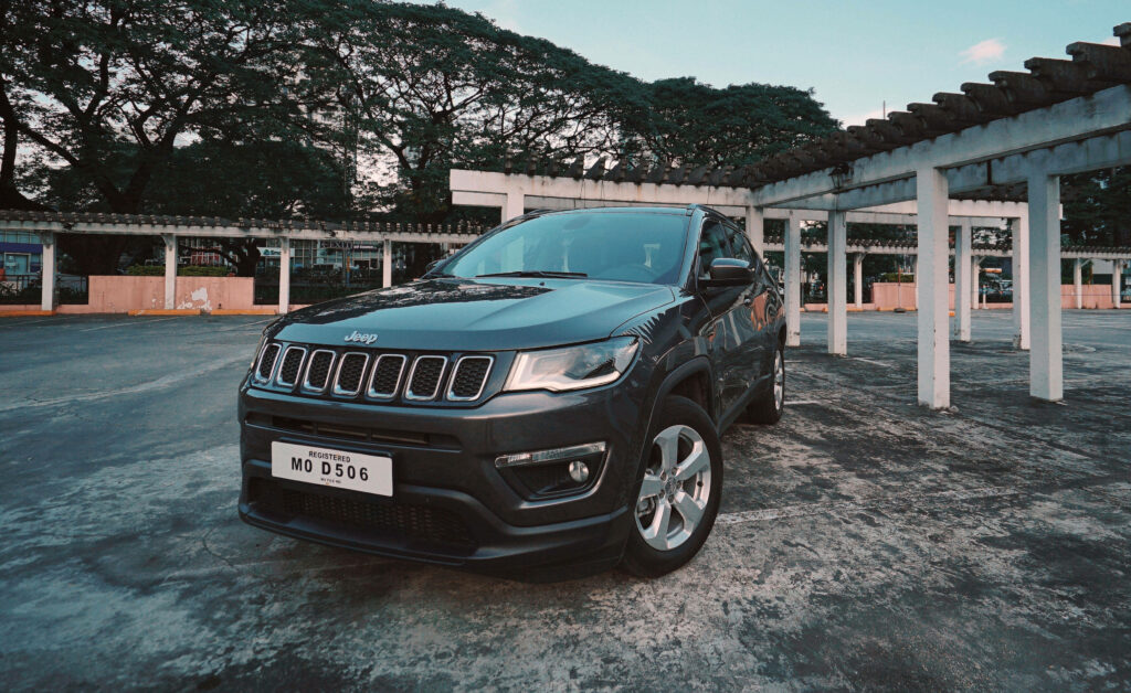 Front view of bold Jeep Compass with sleek headlights and grille in scenic outdoor setting wallpaper