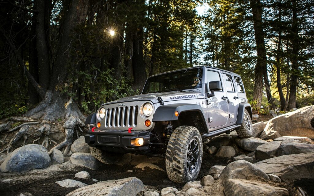 Rugged Jeep Wrangler: Off-Road Adventure Wallpaper in Rocky Forest