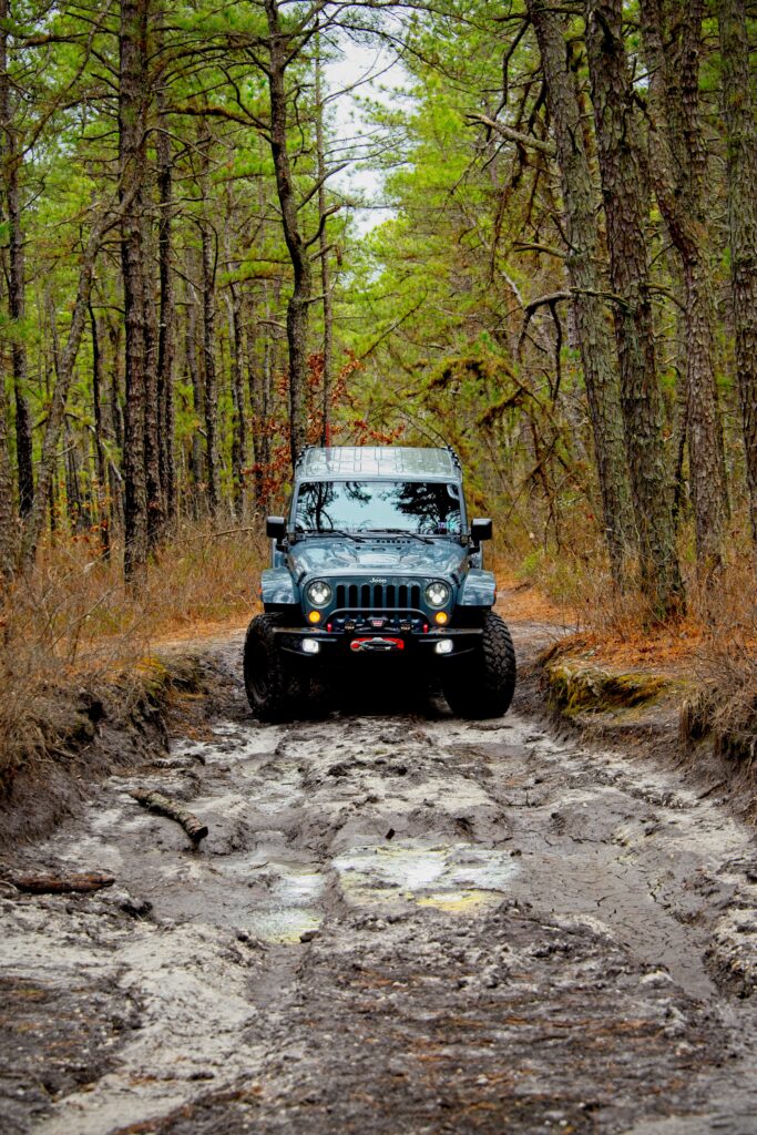 Jeep Wrangler Off-Roading Through Muddy Forest - Stunning Wallpaper