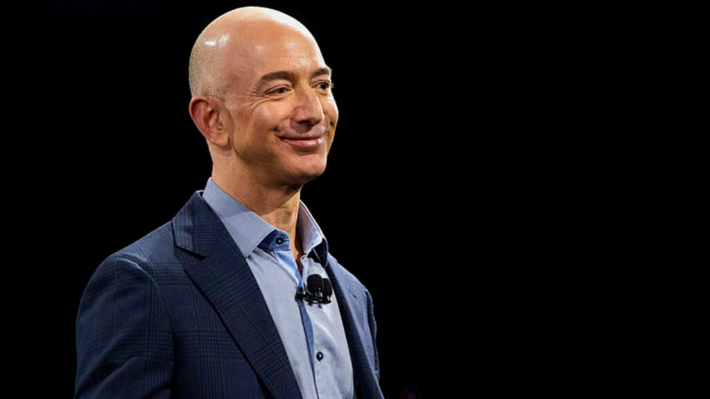Confident Jeff Bezos Wallpaper: Suited Smirk on Dark Background