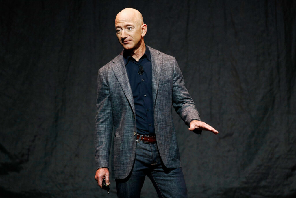 Confident Jeff Bezos in Formal Attire - Dark Wallpaper Background