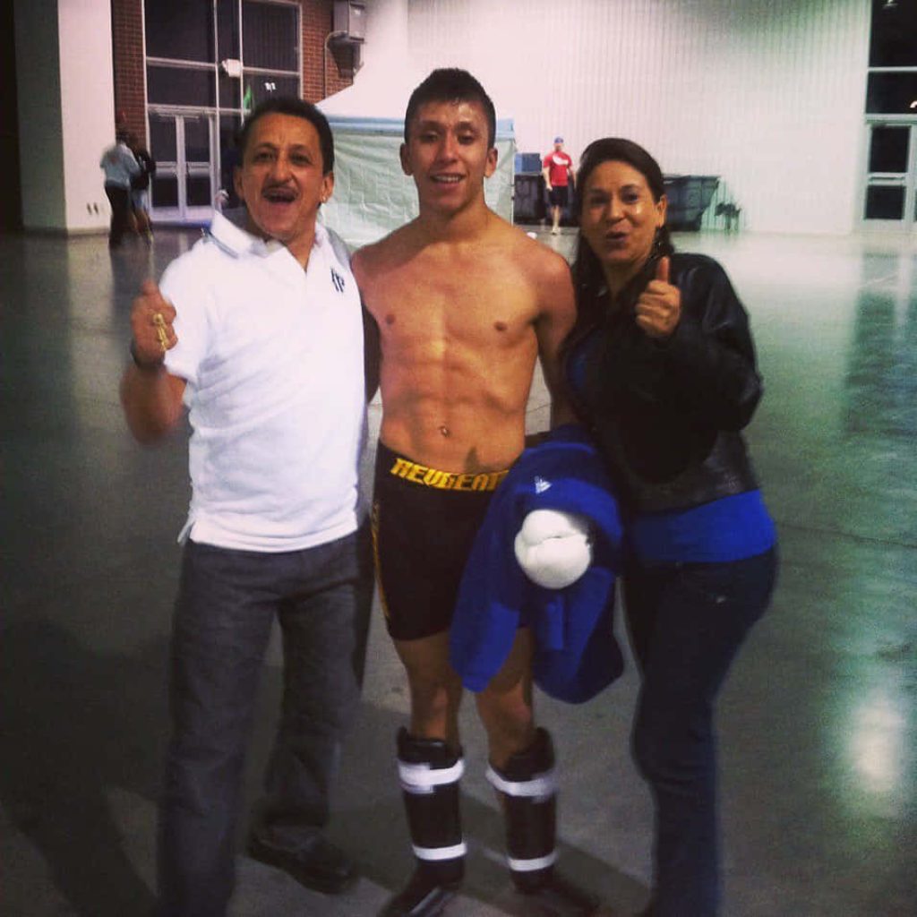 UFC fighter Jeff Molina in fight gear with parents in bright indoor venue family moment wallpaper